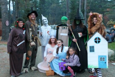 Wizard of Oz characters in costume: Dorothy, Scarecrow, Tin Man, Lion, Witches, and Toto.