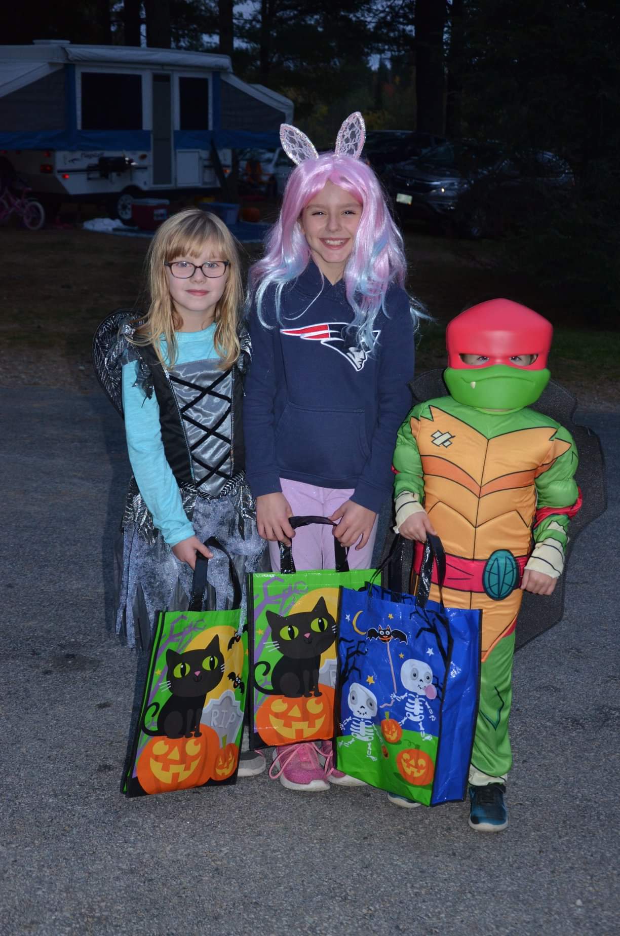 Kids in Halloween costumes with trick-or-treat bags.