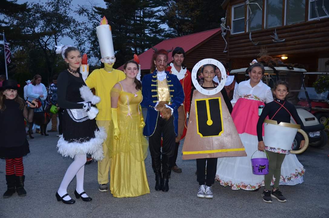 People in Beauty and the Beast costumes, including Lumiere, Belle, Beast, and Cogsworth.